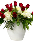 A bouquet of red and white roses arranged in a white vase.